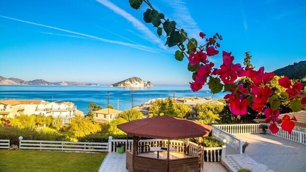 Un gazebo dal tetto rosso con vista sulla costa.