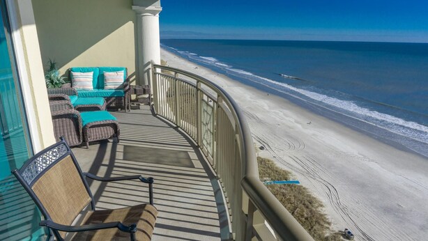 A balcony with wicker furniture and a view of the beach. - MVG 1510 Oceanfront, Penthouse (North Myrtle Beach)