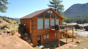 A wooden cabin with a balcony, set in a mountainous area. - The Summit - 3 bedroom 2.5 bathroom home - walk to town (Estes Park)