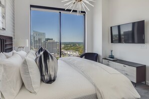 Enjoy a panoramic city view from the large window, with a comfortable bed and a convenient desk for work or relaxation.