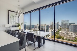 Enjoy a panoramic city view from the comfort of this stylish room, featuring a large window, a minimalist design, and a potted plant.