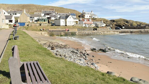 A coastal town with houses along the beach, a rocky shoreline, and a bench on the grass. - 2 bedroom accommodation in Collieston, near Ellon (Collieston, near Ellon)