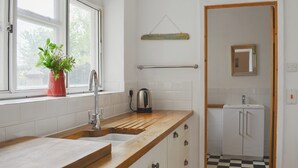 A kitchen with a wooden countertop, a sink, a kettle, and a potted plant. - 3 bedroom accommodation in St Lawrence (St Lawrence)
