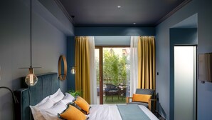 A modern hotel room with a large bed, a desk, and a view of the outdoors. - Olympus Terra Boutique Hotel (Larissa)