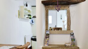 A kitchen with a white countertop, wooden chairs, a radiator, and a shelf with various items. - 2 bedroom accommodation in Bewerley, near Pateley Bridge (Bewerley, near Pateley Bridge)