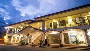 A two-story hotel with a balcony, a staircase, and a reception area.