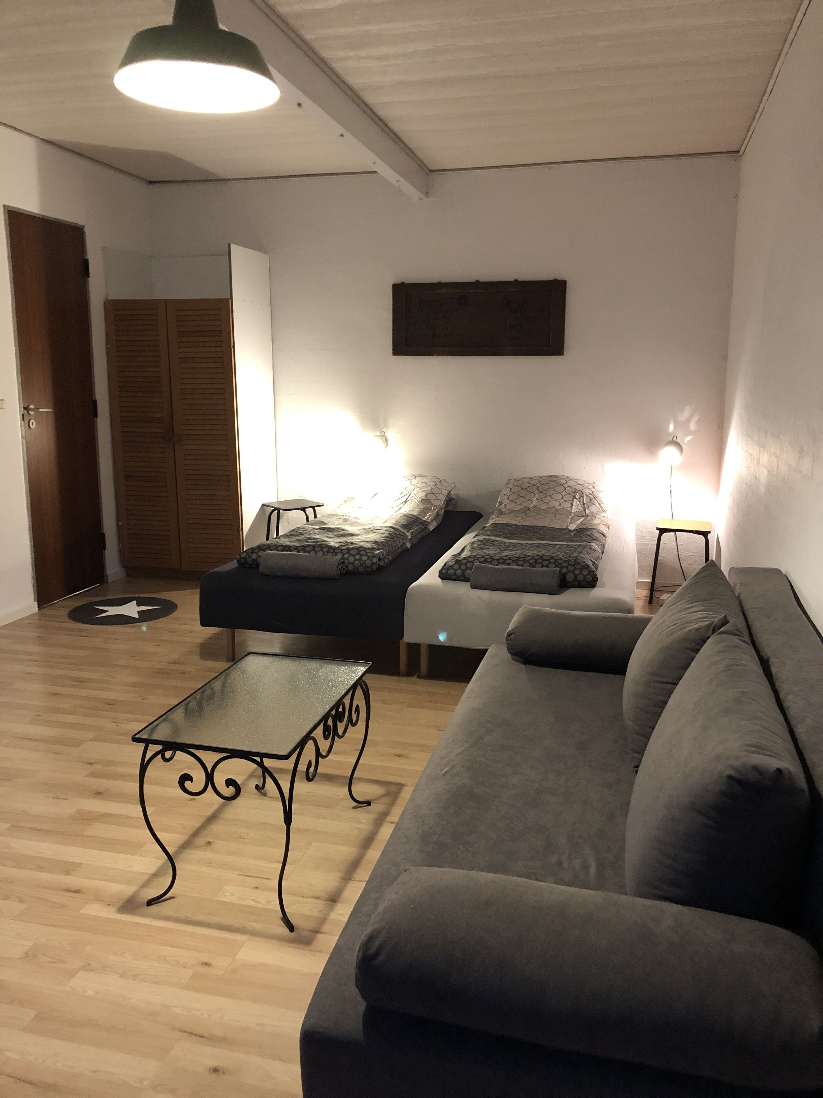 Un salon comprenant un canapé, une table basse et deux lits équipés de lampes.