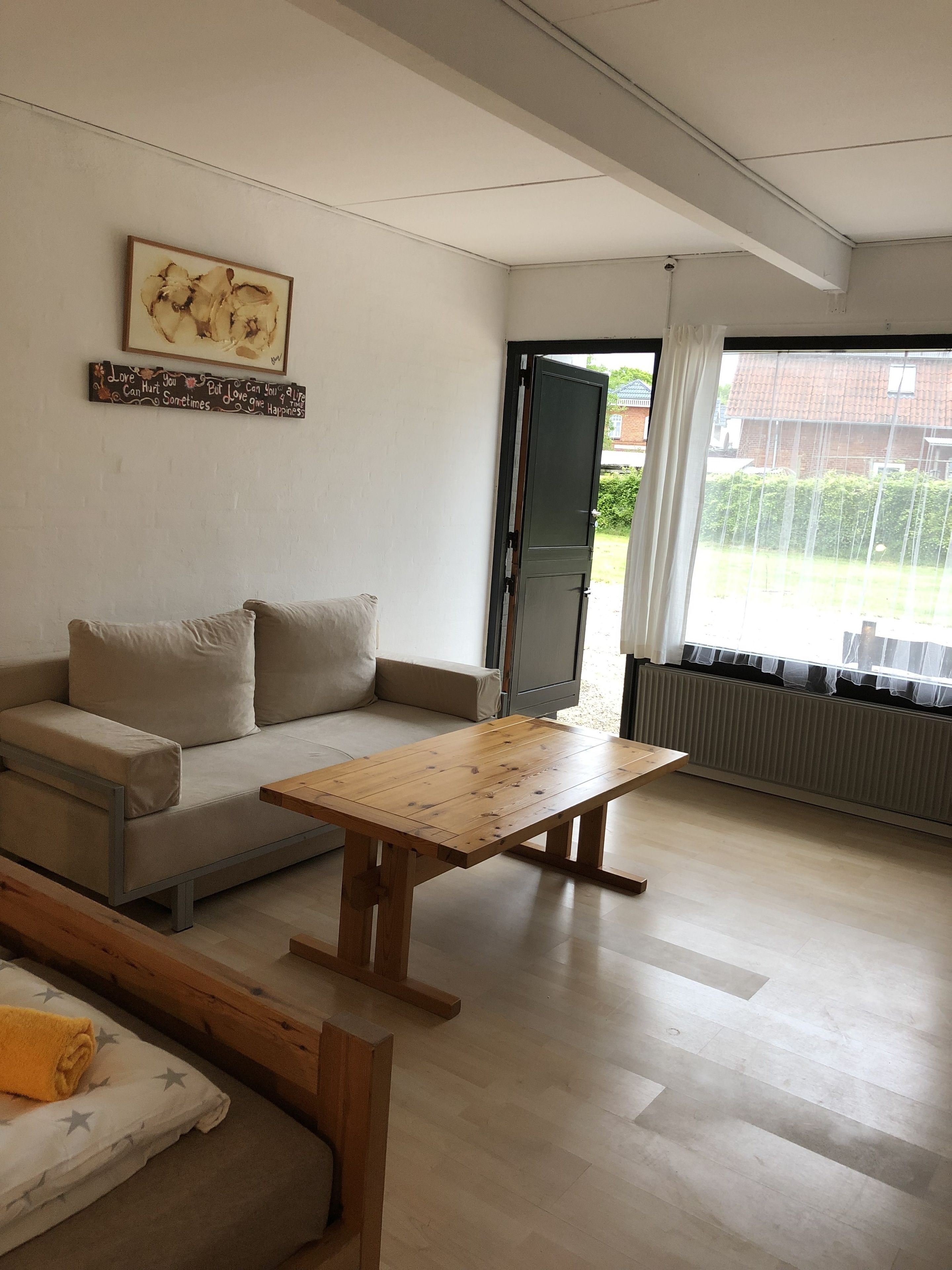 Un salon moderne avec un canapé, une table basse en bois et un radiateur.