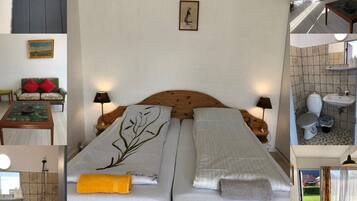 A hotel room with a double bed, a small table, a sofa, a bathroom with a toilet and sink, and a view of the outside.