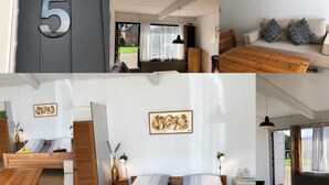 A modern room with a bed, a wooden table, a sofa, and a bathroom with a sink and toilet. - Døstrup Landevejskro & Motel (Skaerbaek)