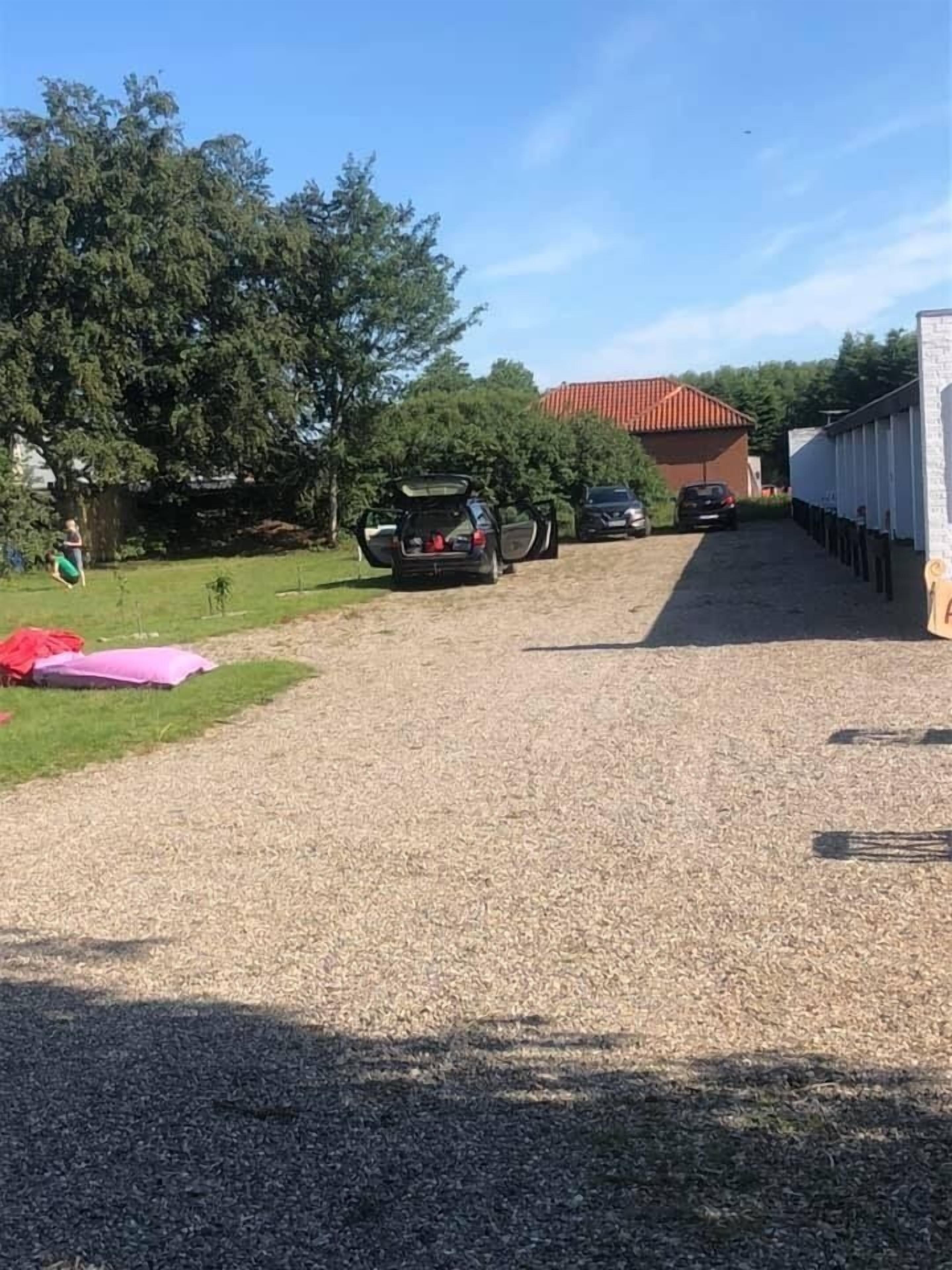 Een grindpad dat leidt naar een gebouw met een rood dak.