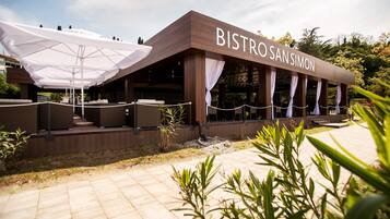 A restaurant named Bistro San Simon with outdoor seating and umbrellas.