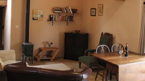 A cozy living room with a fireplace, a wooden table, and a bookshelf. - 3 bedroom accommodation in Llangwm, near Usk (Llangwm, near Usk)