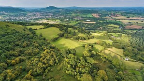 A panoramic view of a rural landscape with rolling hills, fields, and a distant town. - 3 bedroom accommodation in Llangwm, near Usk (Llangwm, near Usk)