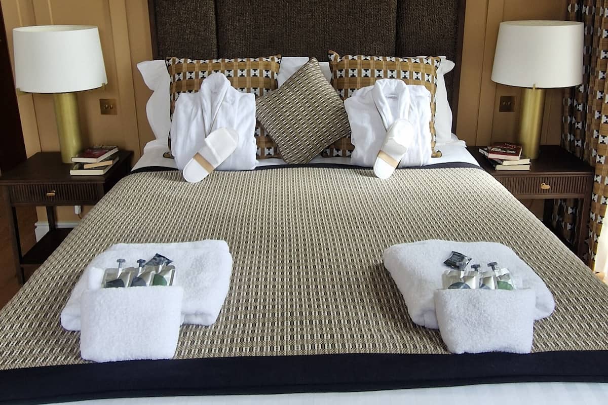 A hotel room with a large bed, two bedside tables, and a headboard.