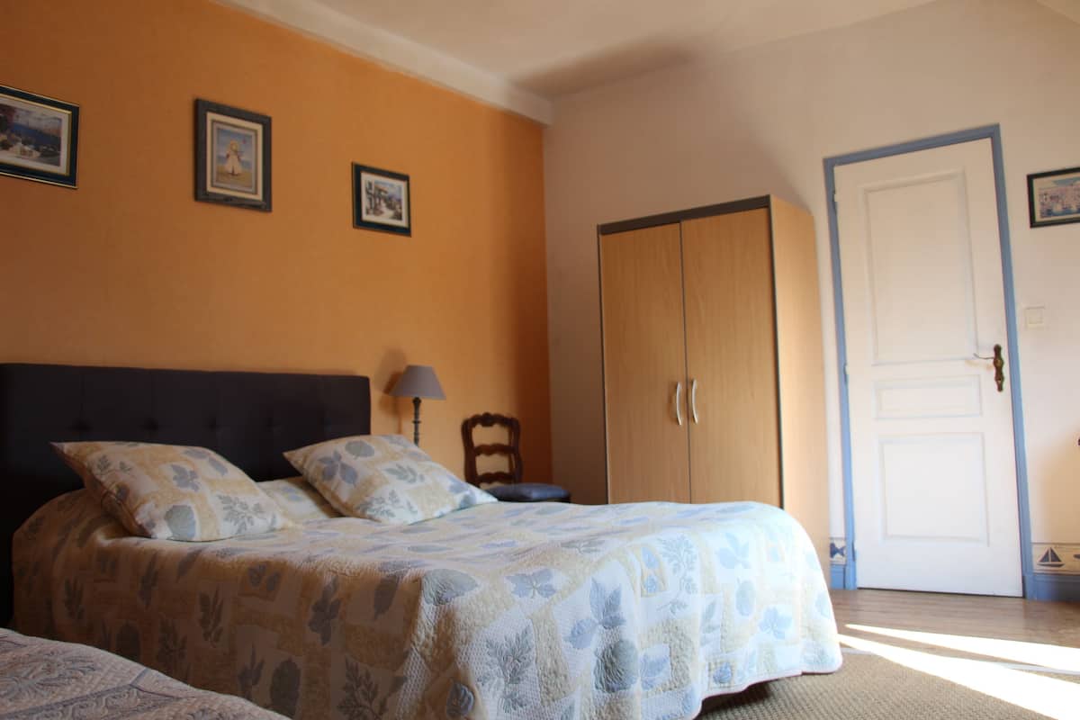 A bedroom with a bed, a wardrobe, and a door.