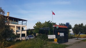 Un edificio con un balcón, una bandera y un letrero.