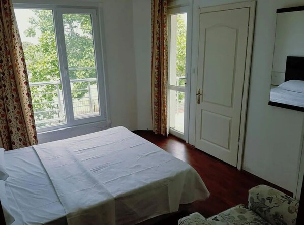 A room with a bed, a door, and a window. - Akmonya Pansiyon (Sarkoy)