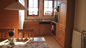 Eine Holz-Küche mit Fenster, Spüle und Herd.