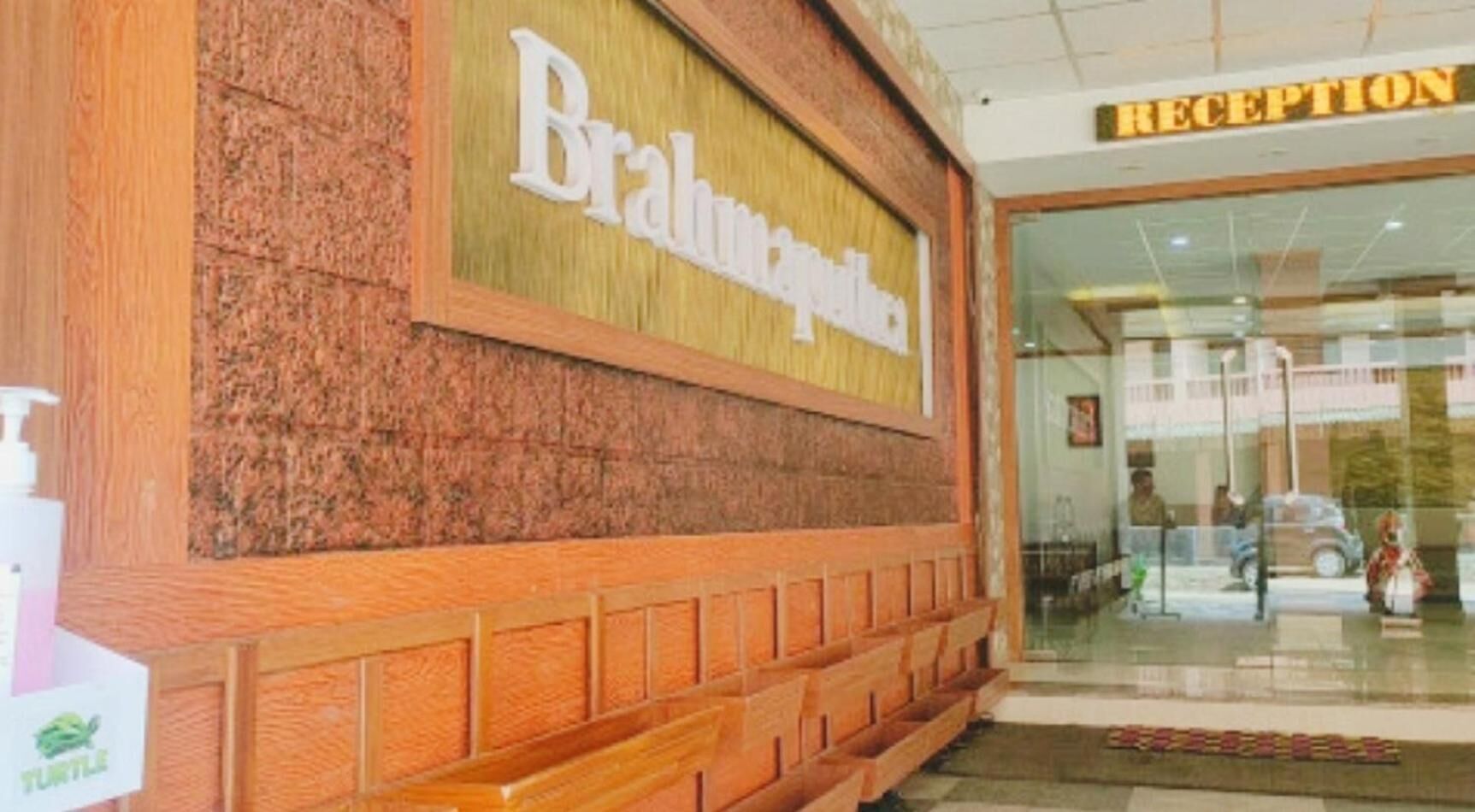 A reception area with a sign that reads "Reception" and a wooden facade with a sign that says "Brahma Palace".