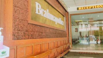 A reception area with a sign that reads "Reception" and a wooden facade with a sign that says "Brahma Palace".