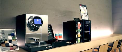 A coffee station with a Nespresso machine, a digital display, and a variety of coffee pods.