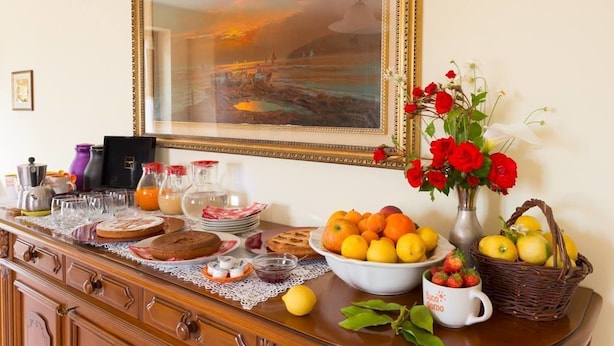 A breakfast table with a painting, flowers, and fruit. - B&B Agrialpi (Bricherasio)
