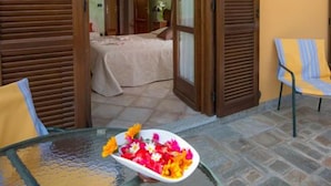 A room with a bed, a glass table with a flower arrangement, and a chair. - B&B Agrialpi (Bricherasio)