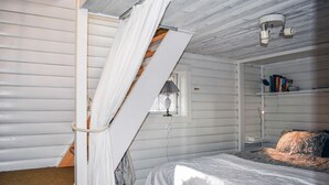 Une chambre à coucher avec un lit, une fenêtre, une bibliothèque et un luminaire au plafond.