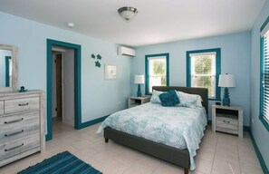 A bedroom with a bed, nightstands, a dresser, and a mirror. - The peace and tranquility of this cottage Works Wonders on the soul.... (Grand Cayman)
