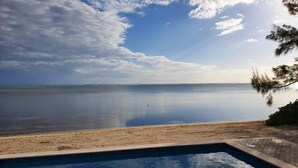 Ein Schwimmbecken mit Blick auf das Meer und den Strand.