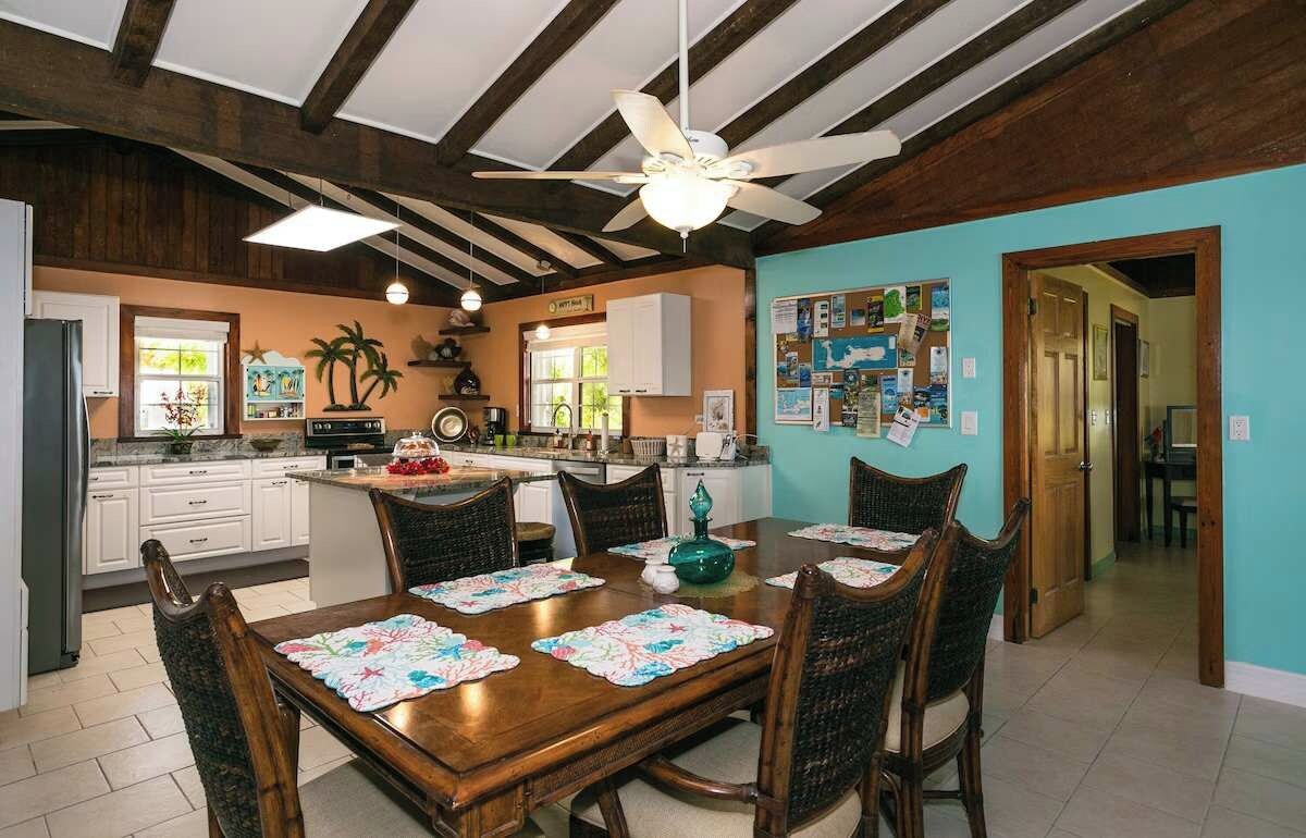 Comedor con mesa de madera, sillas y ventilador de techo.