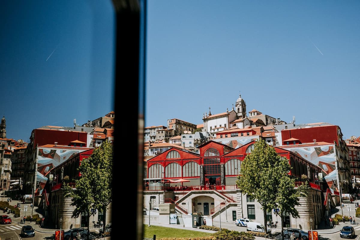 A historic building with a red facade, arched windows, and a central staircase leading to an upper level.