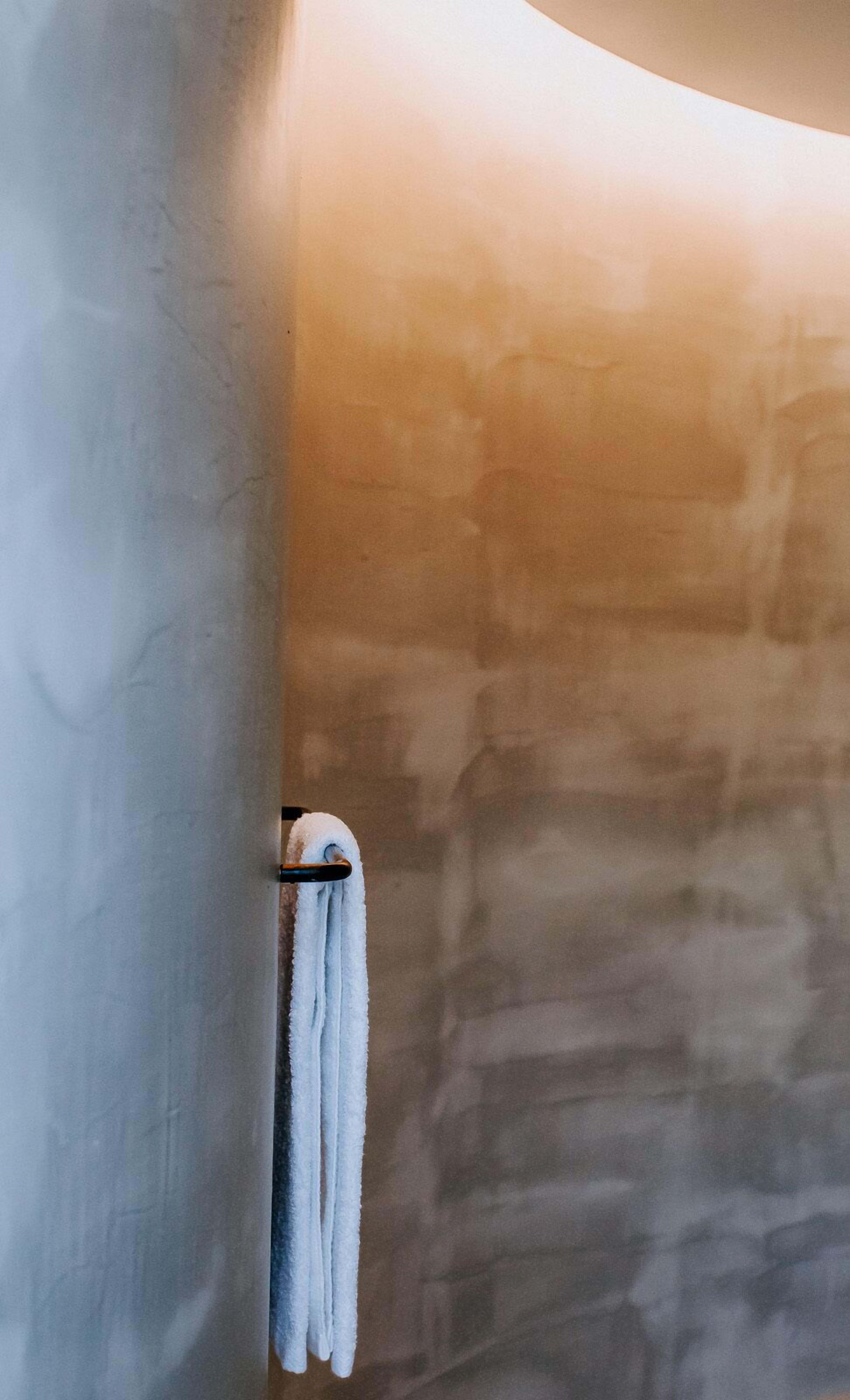 A bathroom with a towel hanging on a metal towel rack.
