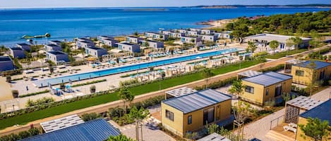 Una piscina al aire libre de temporada, sombrillas, tumbonas