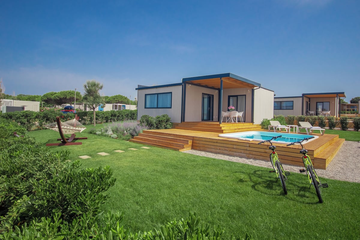 A modern villa with a pool, outdoor seating, and a well-maintained garden.