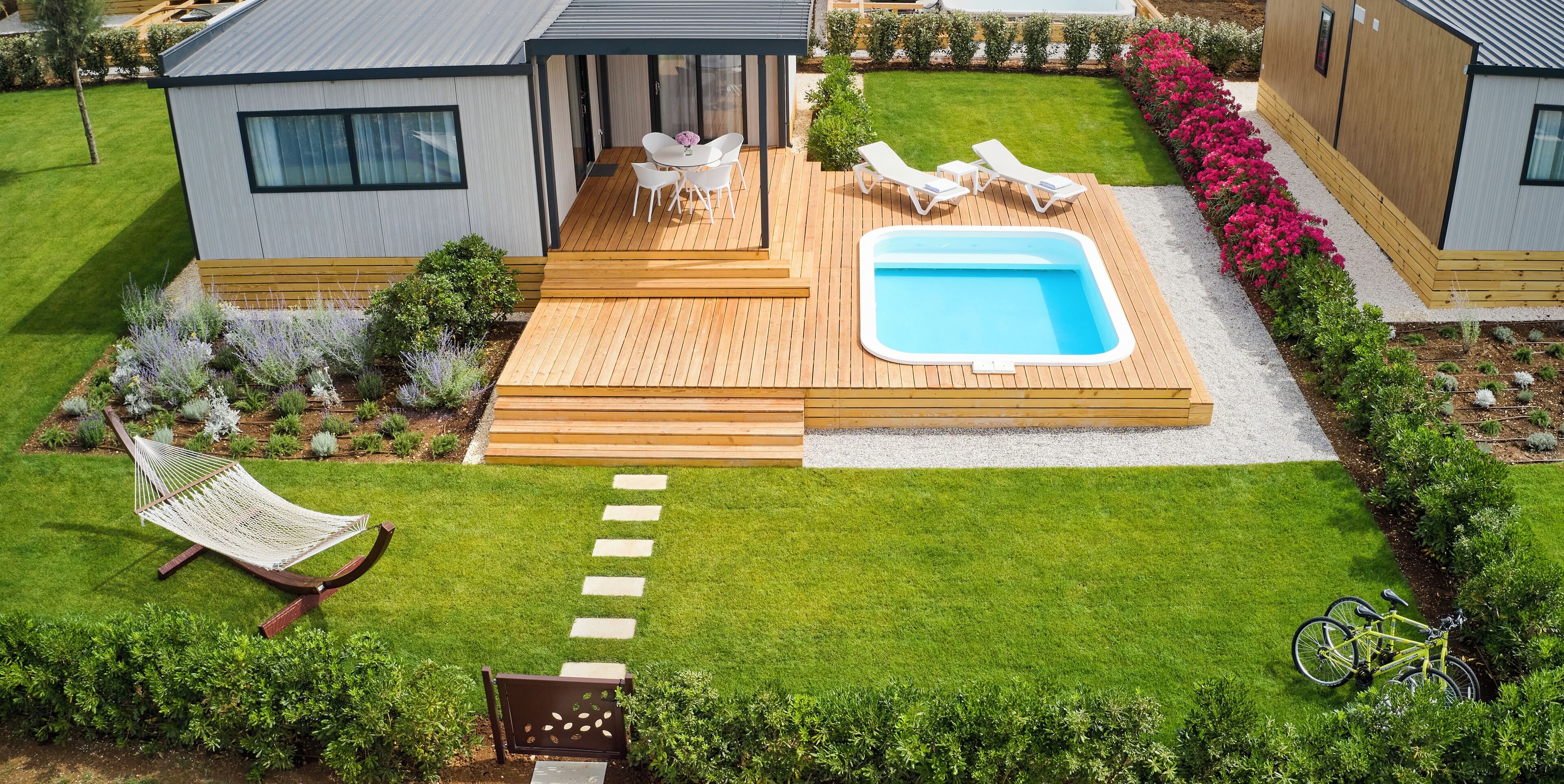 Une terrasse extérieure moderne avec une piscine, des chaises longues et un hamac.