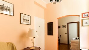 Un salon chaleureux avec un canapé, une lampe et des tableaux encadrés accrochés au mur.