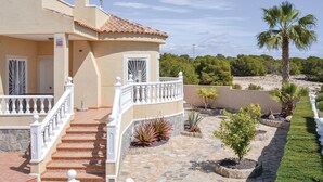 A two-story house with a stone staircase, a balcony with white balustrades, and a garden with various plants and a palm tree. - Amazing home in Quesada-Rojales (Quesada-Rojales)