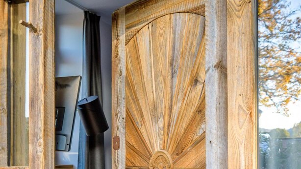 Una puerta de madera con un diseño geométrico y un motivo de abanico.