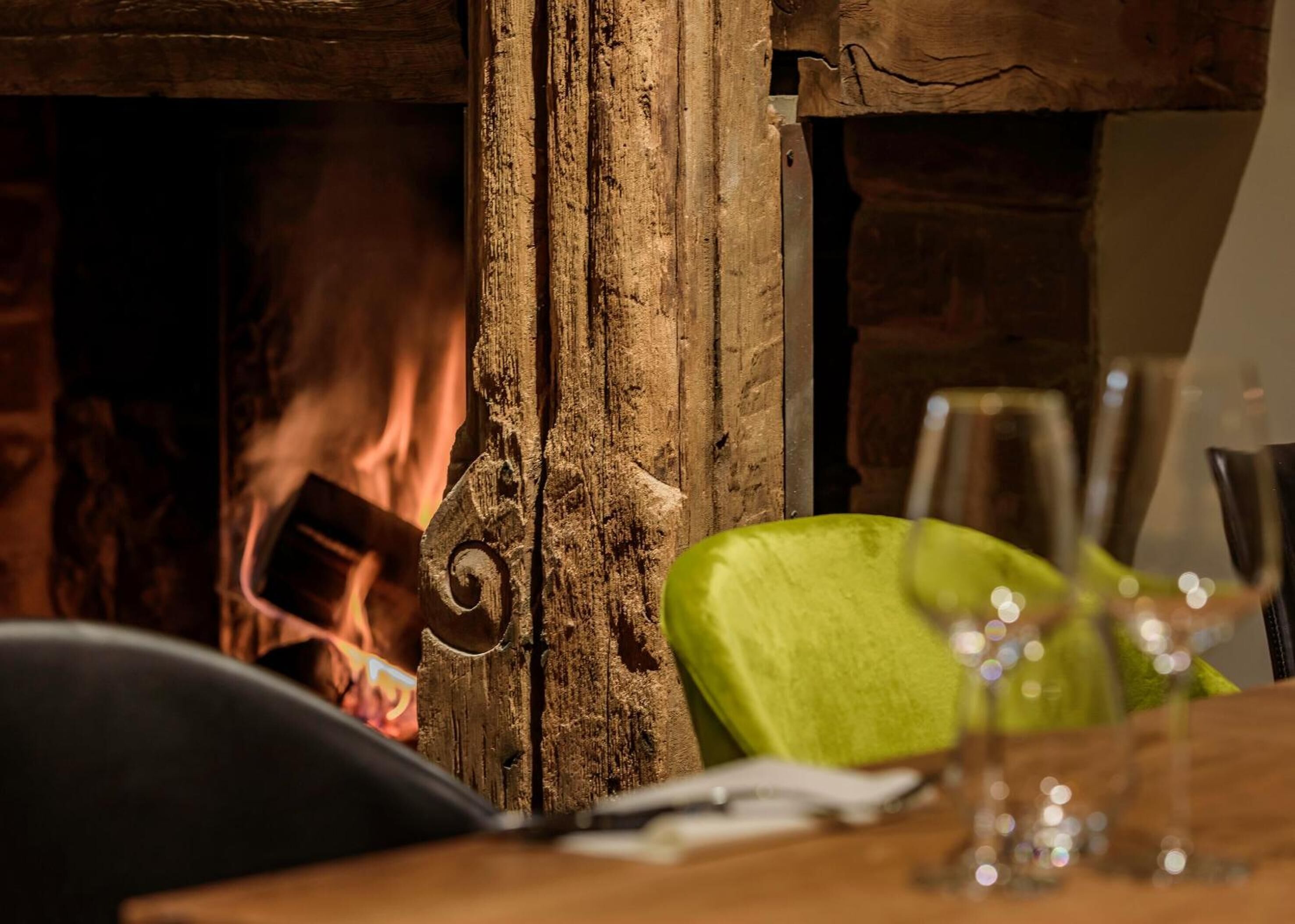 A rustic interior with a wooden wall and a green chair.