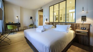 Una habitación de hotel moderna con una cama grande, un escritorio y una silla.