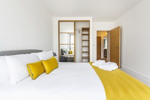 Ein Hotelzimmer mit Bett, Kleiderschrank und einem durchgegangenen Tür sichtbaren Badezimmer.