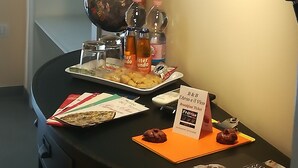 A desk with a globe, bottles, a tray with food, and a sign indicating breakfast availability. - L'arco e il vico (Naples)