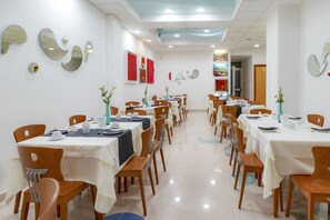 A dining area with multiple tables and chairs, white tablecloths, and decorative mirrors on the walls. - Piccadilly Suites and Rooms (Nardò)