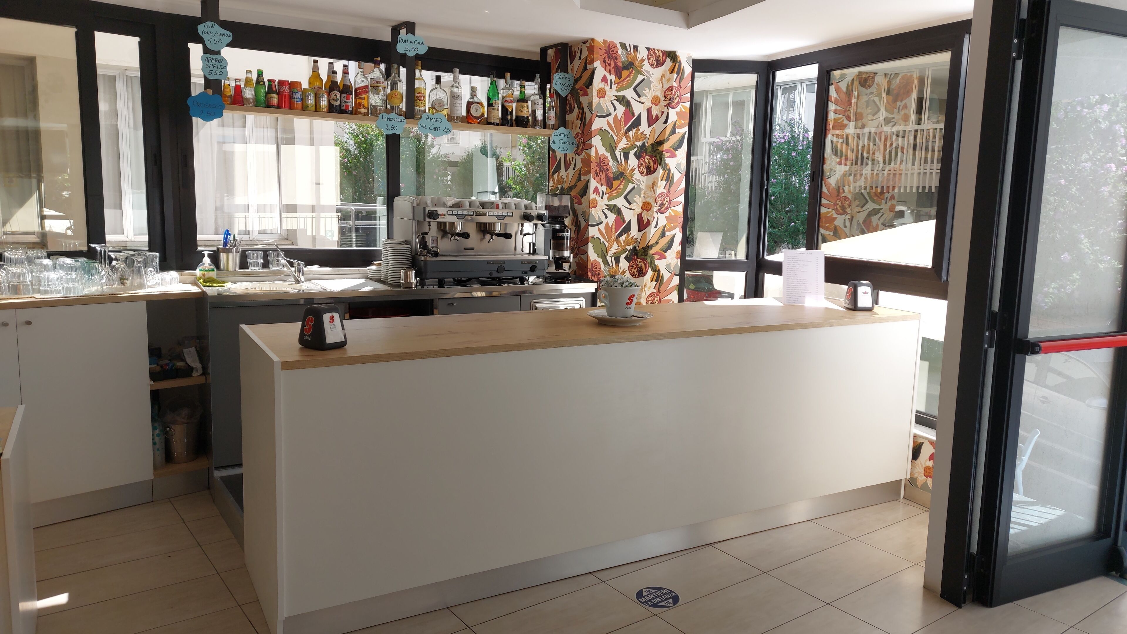 A modern kitchen with a central island, a coffee machine, and various bottles on the counter.
