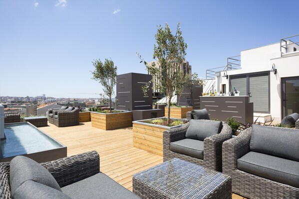 A rooftop terrace with outdoor seating, planters, and a view of the city. - Hotel Acta The Avenue (Porto)