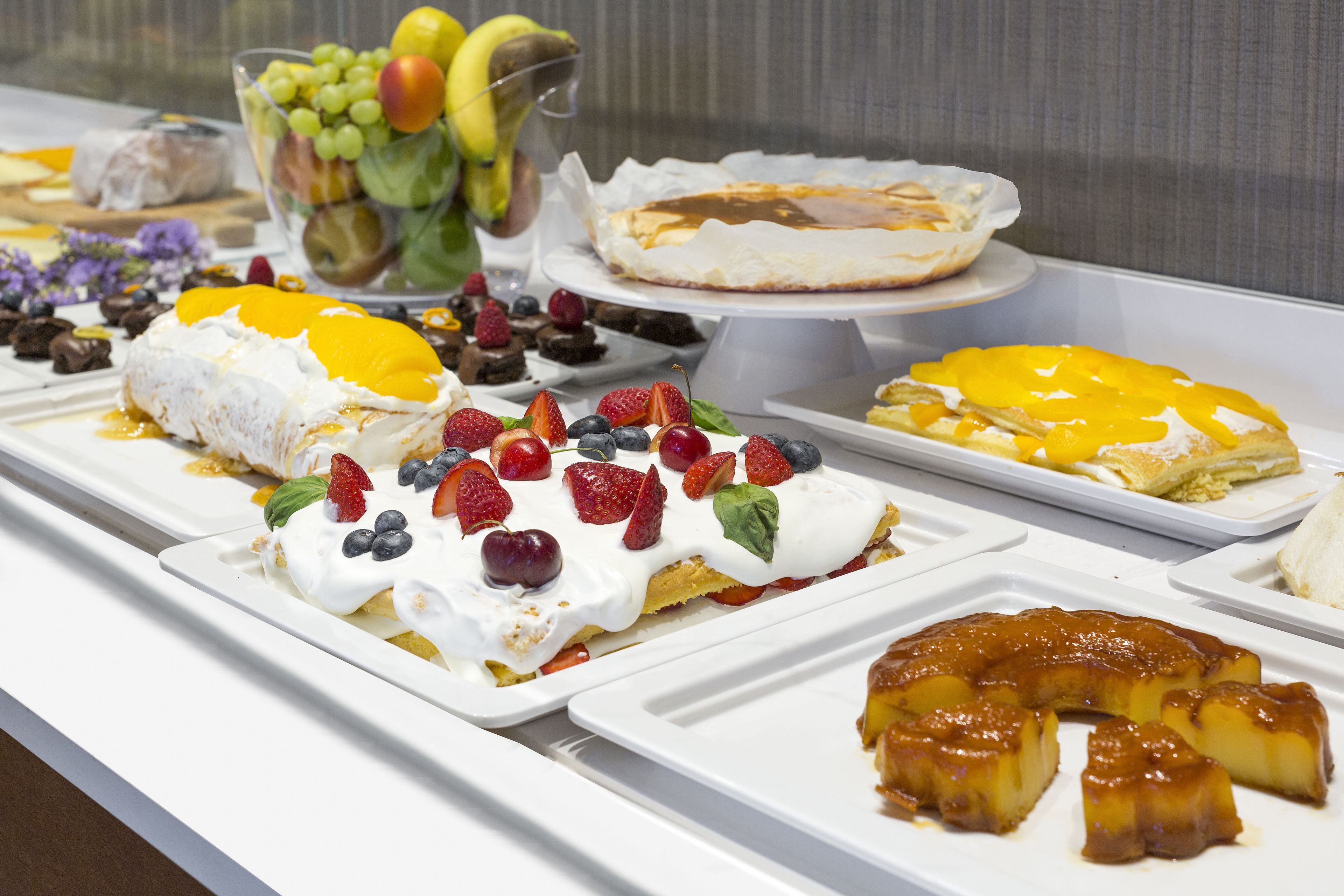 A buffet with various desserts and fruits.