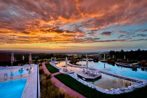 A resort with a swimming pool, outdoor seating, and a view of the landscape. - Der Birkenhof - Spa & Genuss Resort (Neunburg vorm Wald)