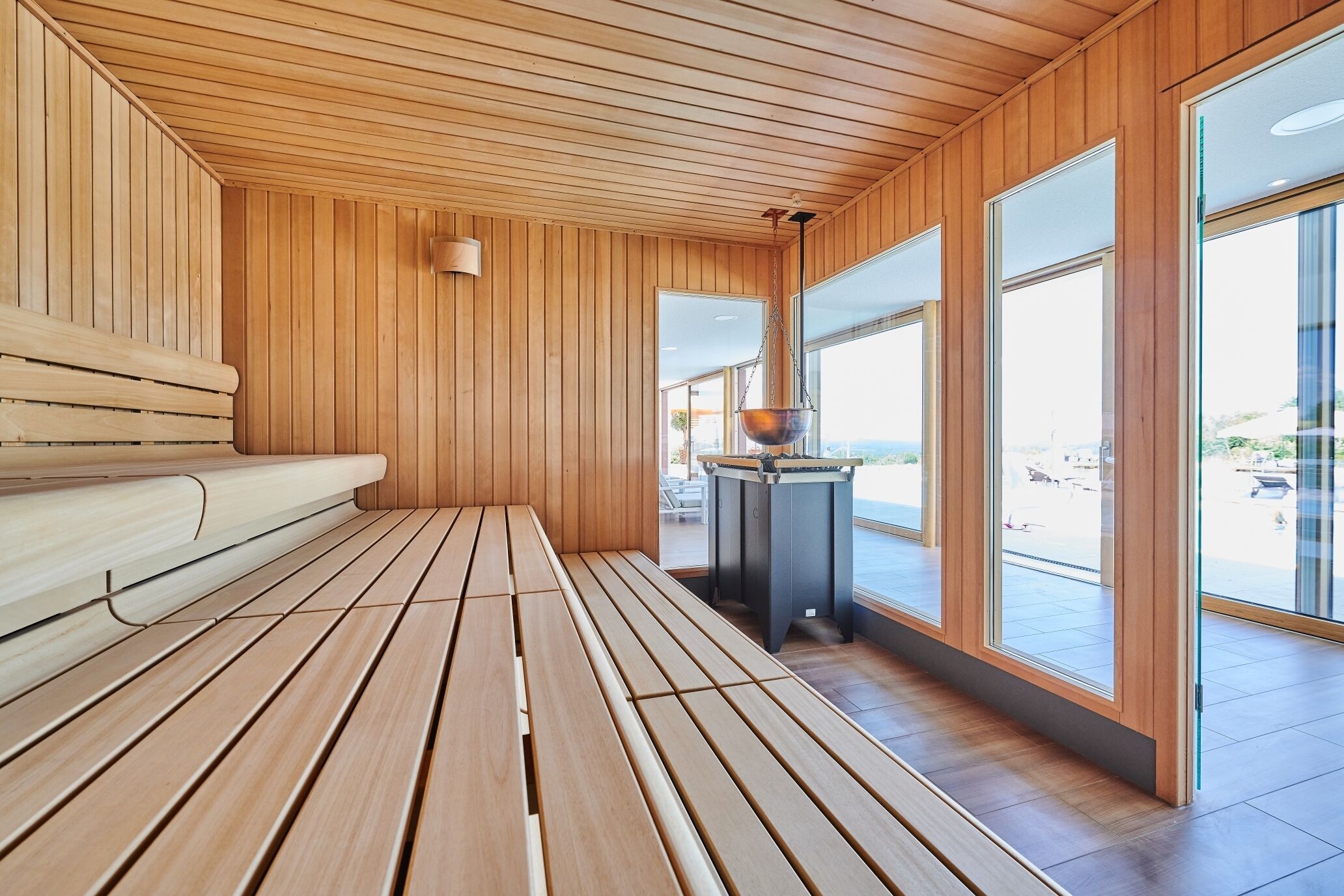 A wooden sauna room with benches and a table.